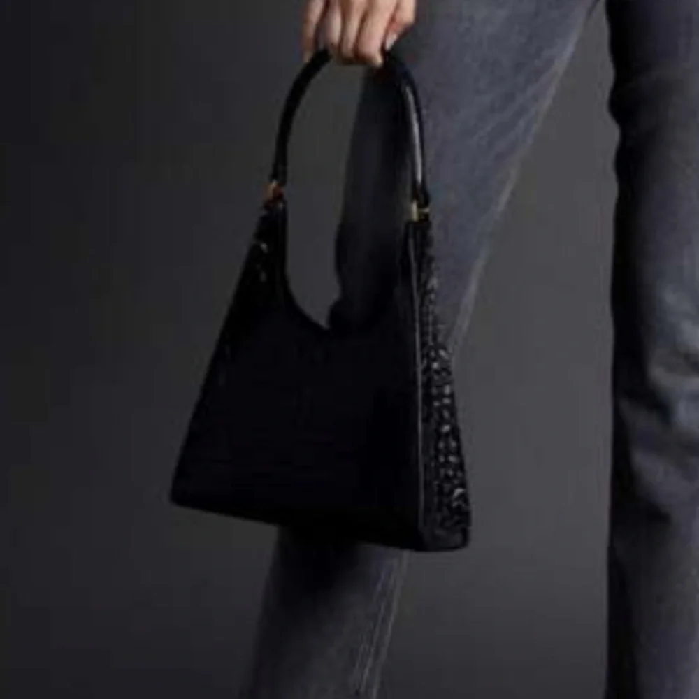 The STAUD Rey Bag in black is a triangular leather bag featuring a top handle - Picture 2 of 5